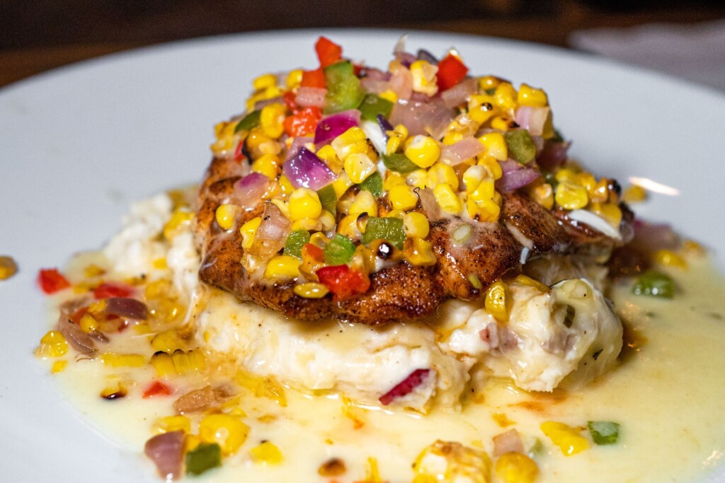a loaded redfish dish with corn and potatoes